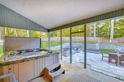 an outdoor kitchen with a large expanse of glass windows at 7 Mi to Skiing Lake George Home with Large Patio in Queensbury