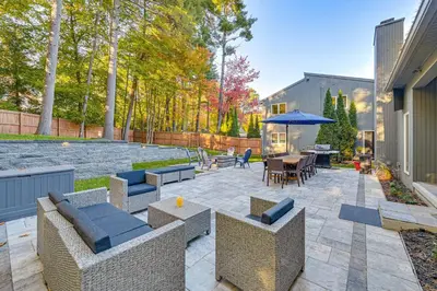 a patio with a table and chairs and an umbrella at 7 Mi to Skiing Lake George Home with Large Patio in Queensbury