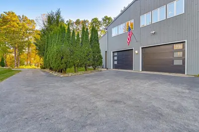 a parking lot in front of a building with a garage at 7 Mi to Skiing Lake George Home with Large Patio in Queensbury