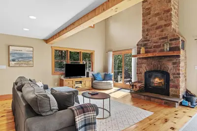 a living room with a couch and a fireplace at New! 3BR Contemporary Log Home in Catskill Mtns in Margaretville