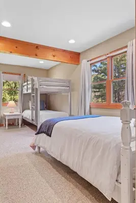a bedroom with a white bed and two windows at New! 3BR Contemporary Log Home in Catskill Mtns in Margaretville