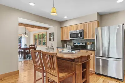 a kitchen with wooden cabinets and a stainless steel refrigerator at New! 3BR Contemporary Log Home in Catskill Mtns in Margaretville