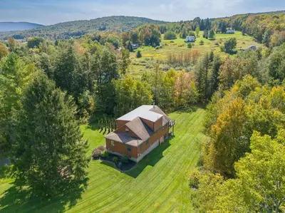 an aerial view of a house in the middle of a field at New! 3BR Contemporary Log Home in Catskill Mtns in Margaretville