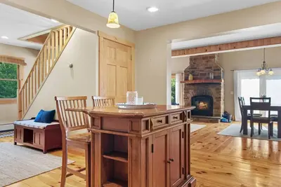 a living room with a table and a fireplace at New! 3BR Contemporary Log Home in Catskill Mtns in Margaretville