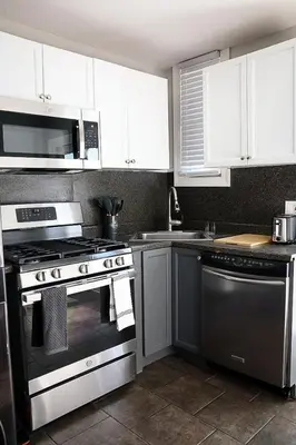 a kitchen with stainless steel appliances and white cabinets at Modern 2BR, Easy access to NYC in Jersey City