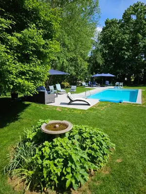 a backyard with a swimming pool and a fountain in the grass at Heart Historic Ridgefield Studio WALK to town in Ridgefield