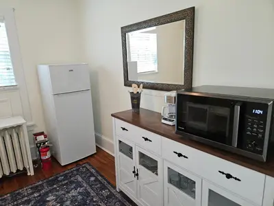 a kitchen with a microwave and a mirror on the wall at Heart Historic Ridgefield Studio WALK to town in Ridgefield