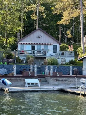 a house sitting on the water with a dock at Lake Moraine Home #7 Near Colgate University in Hamilton