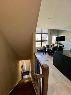 a staircase leading to a living room and dining room at Charles Peak Condo - JC Heights in Jersey City