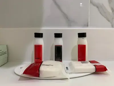 three bottles of milk and a plate on a shelf at Voyage Hotel in Long Island City