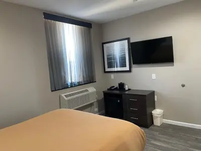 a hotel room with a bed and a flat screen tv at Voyage Hotel in Long Island City