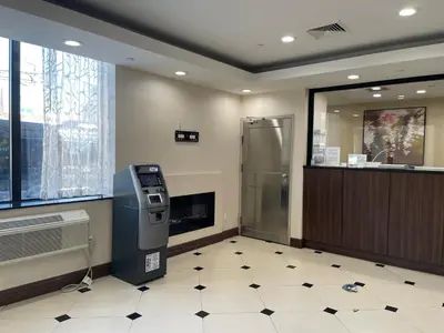 an atm machine in a waiting room with a window at Voyage Hotel in Long Island City