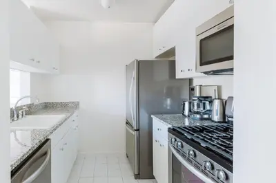 a kitchen with a stainless steel refrigerator and a sink at Blueground Upper West Side nr parks wd NYC-1678 in New York