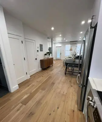 a kitchen and living room with a wooden floor at Stunning Family Style Duplex in New York