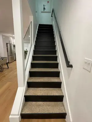 a stairway with black and white stairs in a house at Stunning Family Style Duplex in New York