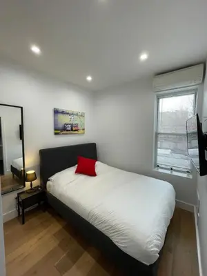 a bedroom with a bed with a red pillow on it at Stunning Family Style Duplex in New York