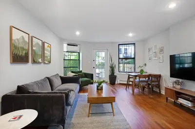 a living room with a couch and a table at Charming Central Park Townhome in New York