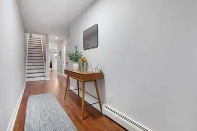 a hallway with a table with flowers on a wall at Charming Central Park Townhome in New York