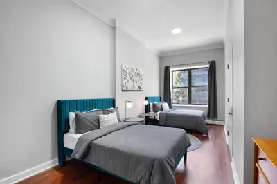 a bedroom with two beds and a window at Charming Central Park Townhome in New York