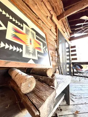 a sign on the side of a log cabin with a chair at Cozy, Modern Cabin Retreat 8 min to Windham mtn in Ashland