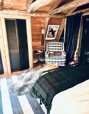 a bedroom with a bed and a chair in a room at Cozy, Modern Cabin Retreat 8 min to Windham mtn in Ashland