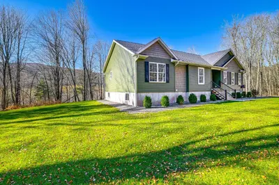 a green house on a green grassy field at Mountain Views and Brook Access Home in Arkville! in Arkville