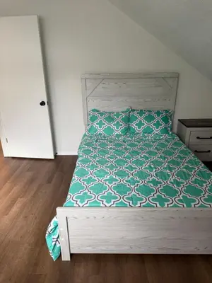 a bedroom with a bed with a green and white comforter at poconos mountain luxury cozy vacational house in the heart of Poconos in Tobyhanna