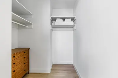 a hallway with white walls and a wooden dresser at Blueground Downtown BK gym wd nr BAM NYC-1685 in Brooklyn