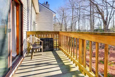a wooden balcony with a chair on a house at Walk to Mt Snow Cozy West Dover Condo in West Dover