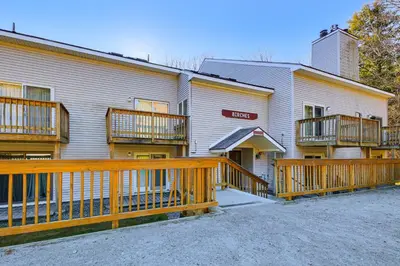 a building with wooden balconies on the side of it at Walk to Mt Snow Cozy West Dover Condo in West Dover