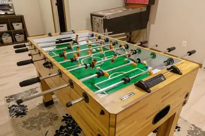 a wooden foosball table with avertisement for at Woodland Cabin Getaway in Greentown