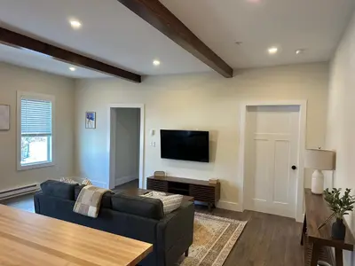 a living room with a couch and a flat screen tv at The Innwoods - Two Bedroom Apartment in Tannersville