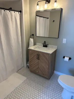 a bathroom with a sink and a mirror and a toilet at The Innwoods - Two Bedroom Apartment in Tannersville