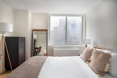 a bedroom with a large white bed with a window at Blueground Midtown E gym wd nr UN NYC-1150 in New York