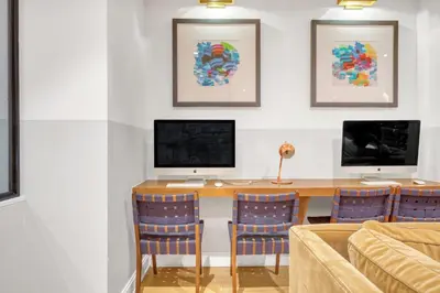 a room with a desk with a computer and chairs at Blueground Midtown E gym wd nr UN NYC-1150 in New York