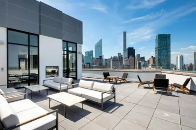 a rooftop patio with furniture and a view of the city at Blueground Midtown E gym wd nr UN NYC-1150 in New York