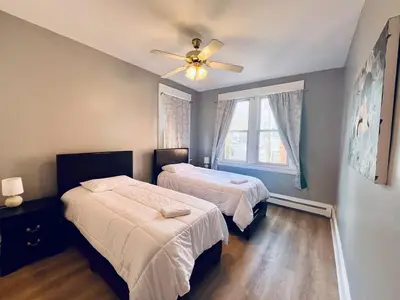 a bedroom with two beds and a ceiling fan at Spacious 3-bedroom Apartment Stunning Views NYC in Union City