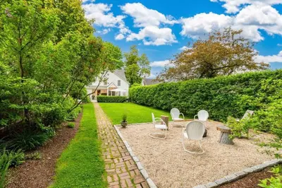a garden with chairs and a table in a yard at The 1782 Darling House on the Litchfield Green in Litchfield