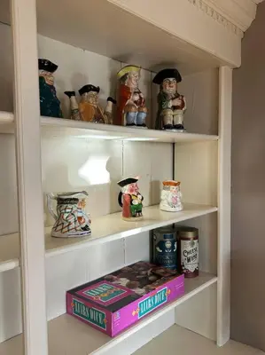 a shelf with a book and some figurines on it at The 1782 Darling House on the Litchfield Green in Litchfield