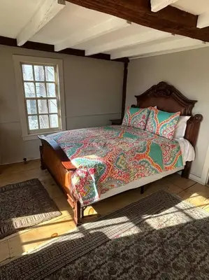 a bedroom with a bed with a quilt on it at The 1782 Darling House on the Litchfield Green in Litchfield