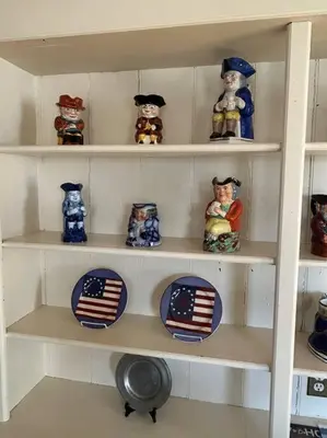 a white shelf with plates and figurines on it at The 1782 Darling House on the Litchfield Green in Litchfield