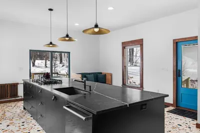a kitchen with a black counter top and some windows at Casa Catskills in Margaretville
