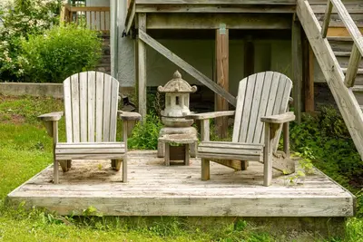 two chairs and a bird feeder on a wooden deck at Casa Catskills in Margaretville