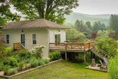 a house with a wooden deck in the yard at Casa Catskills in Margaretville