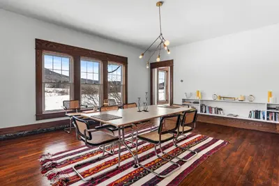 a dining room with a table and chairs on a rug at Casa Catskills in Margaretville
