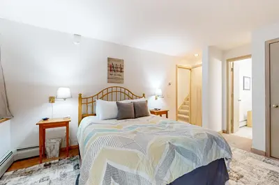 a bedroom with a bed and two tables and a hallway at Haystack 9 in Wilmington