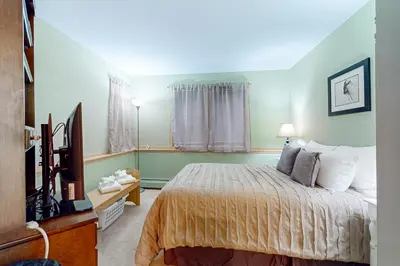 a bedroom with a bed and a flat screen tv at Haystack 9 in Wilmington
