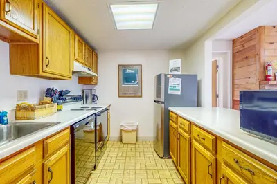 a kitchen with wooden cabinets and a stainless steel refrigerator at Snow Tree 32A in Dover