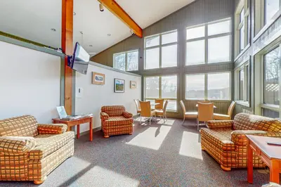 a living room with couches and tables and windows at Snow Tree 32A in Dover