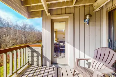 a porch with a rocking chair on a house at Snow Tree 32A in Dover